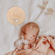 Exemple de support souvenir de naissance présenté près d’un bébé
