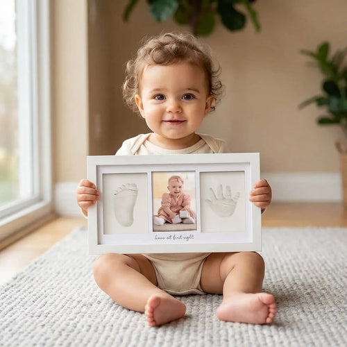 Enfant tenant un cadre souvenir avec photo et empreintes de bébé