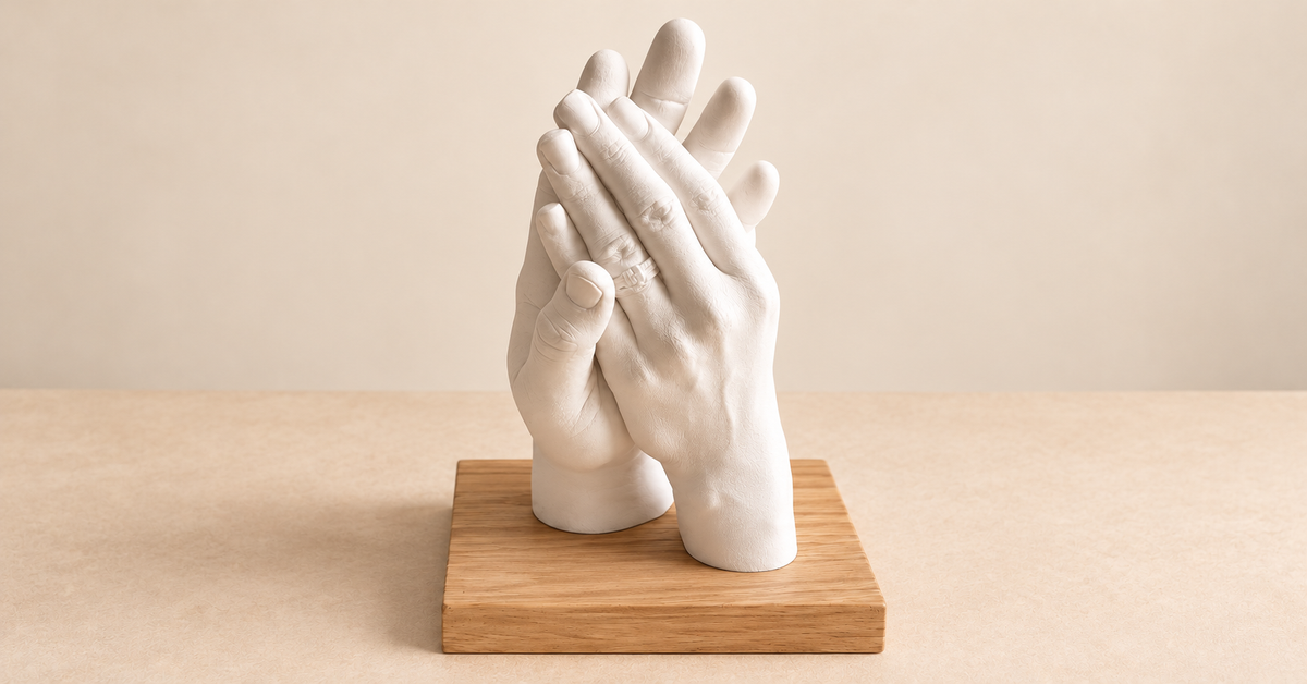 Moulage de deux mains en plâtre sur un socle en bois